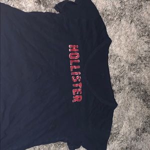 blue cropped shirt with red and gold letters